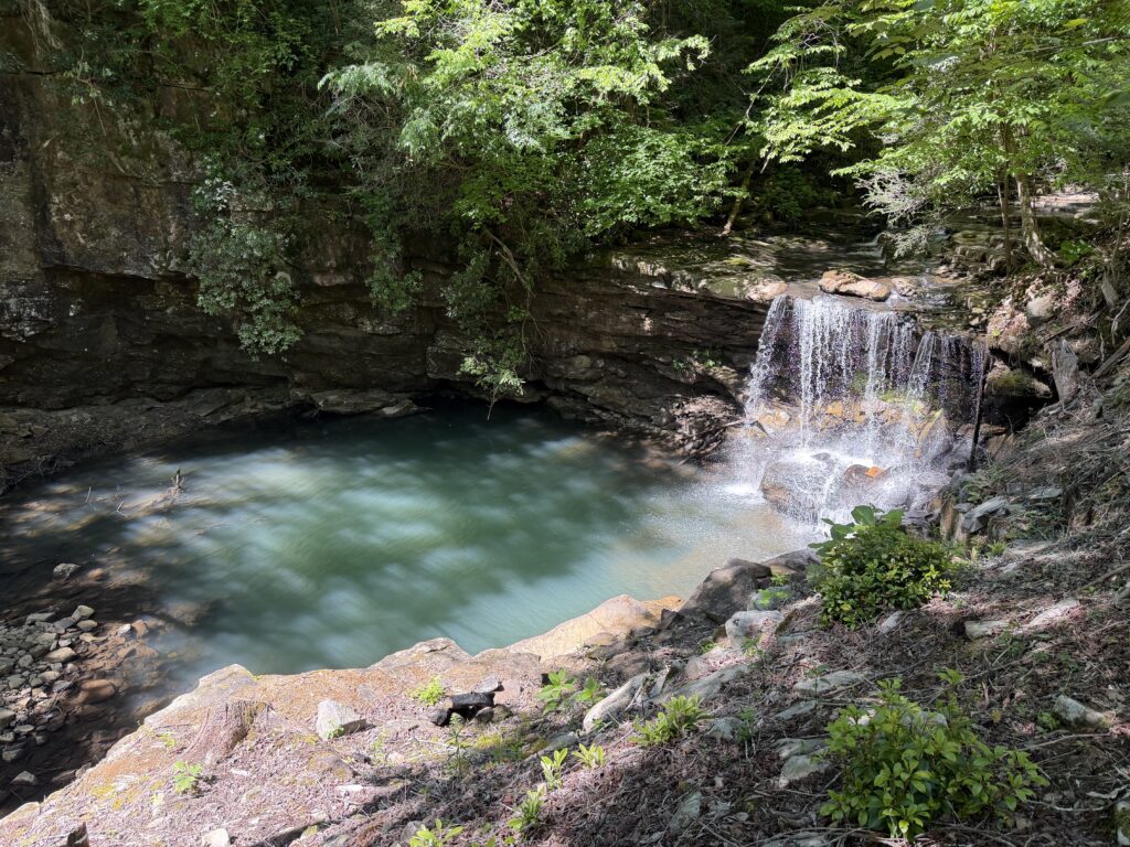Waterfall and turquoise swimming hole on Pond Creek, part of The Canyon at Pond Creek property in Pikeville, Tennessee